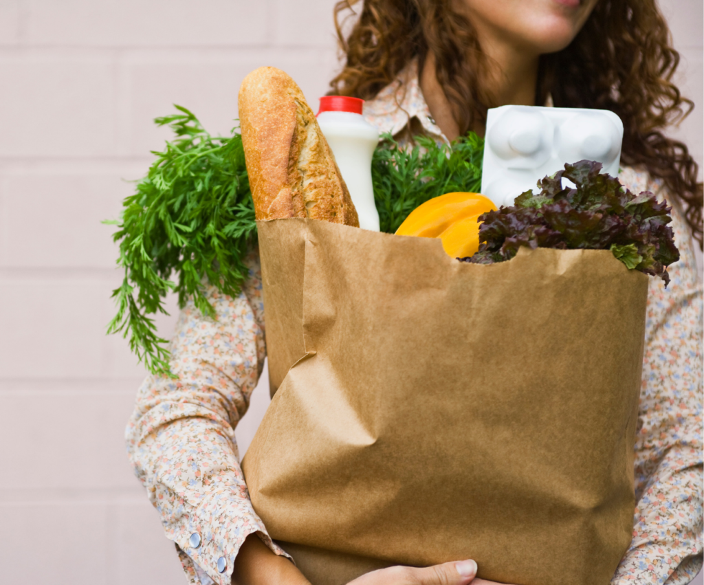 person holding a grocery bag with food