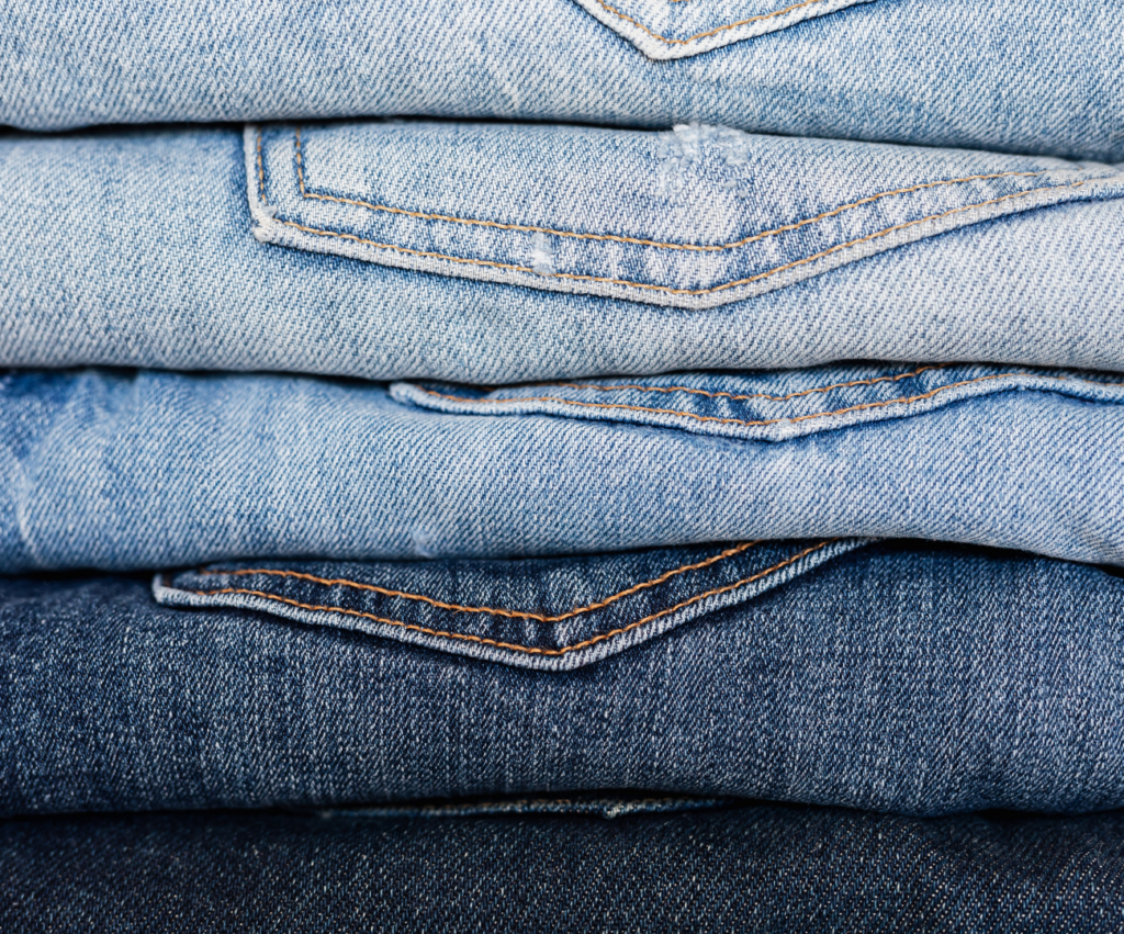 a stack of denim jeans from light to dark