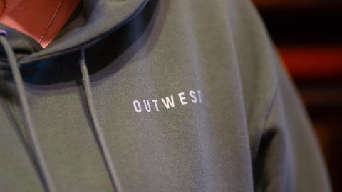 Details shot of the front of the Outwest Aistear hoodie including drawstrings adn logo
