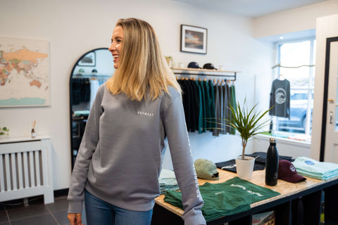 Girl smiling in clothing store wearing Outwest crewneck jumper