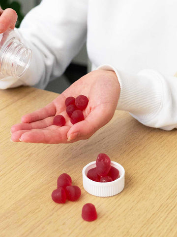 Eine Frau hält die CBD Fruchtgummis (1500mg) Beeren.