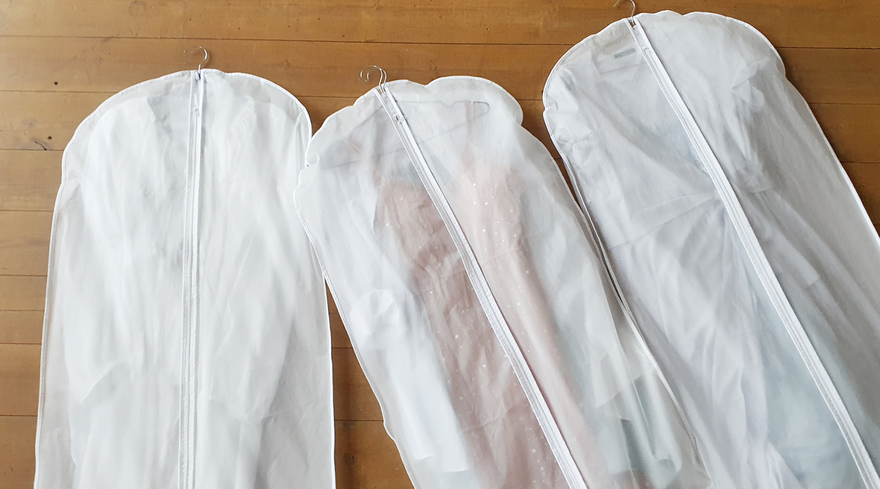 Three white garment bags.
