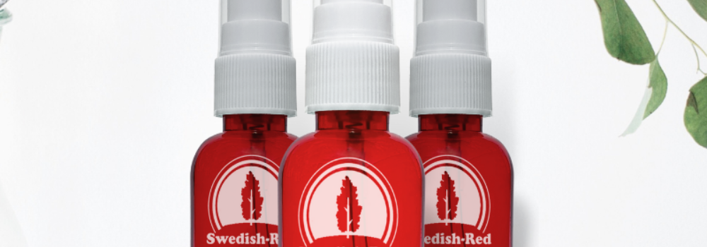 Three red spray bottles with Swedish Red red cedar oil.