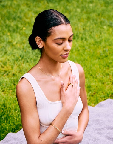 woman meditating in nature with her health tracking ring