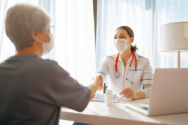 A patient talking and shaking hands with their doctor