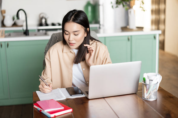 Woman doing research at her kitchen table