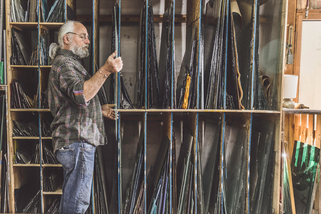 artisan holding and inspecting a fusible glass panel