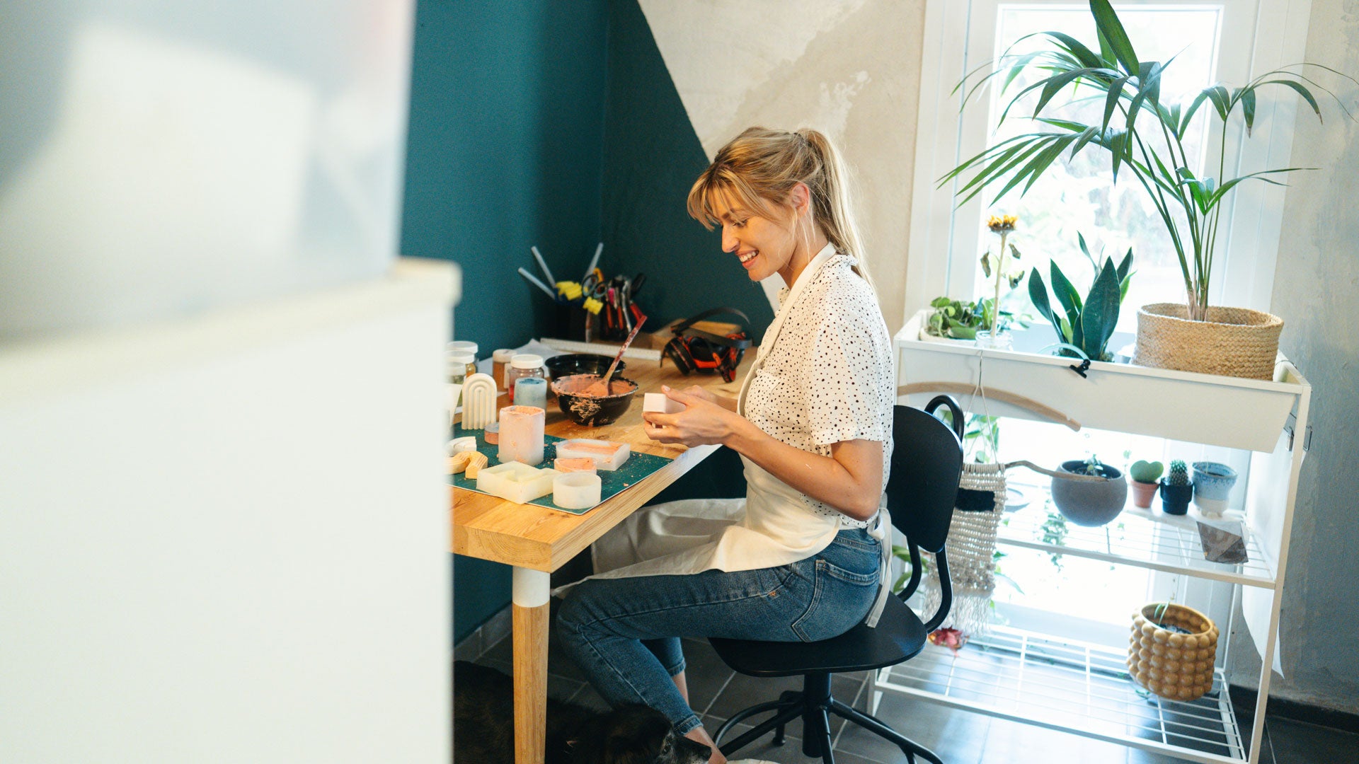 A woman sitting at a table working on glass molds