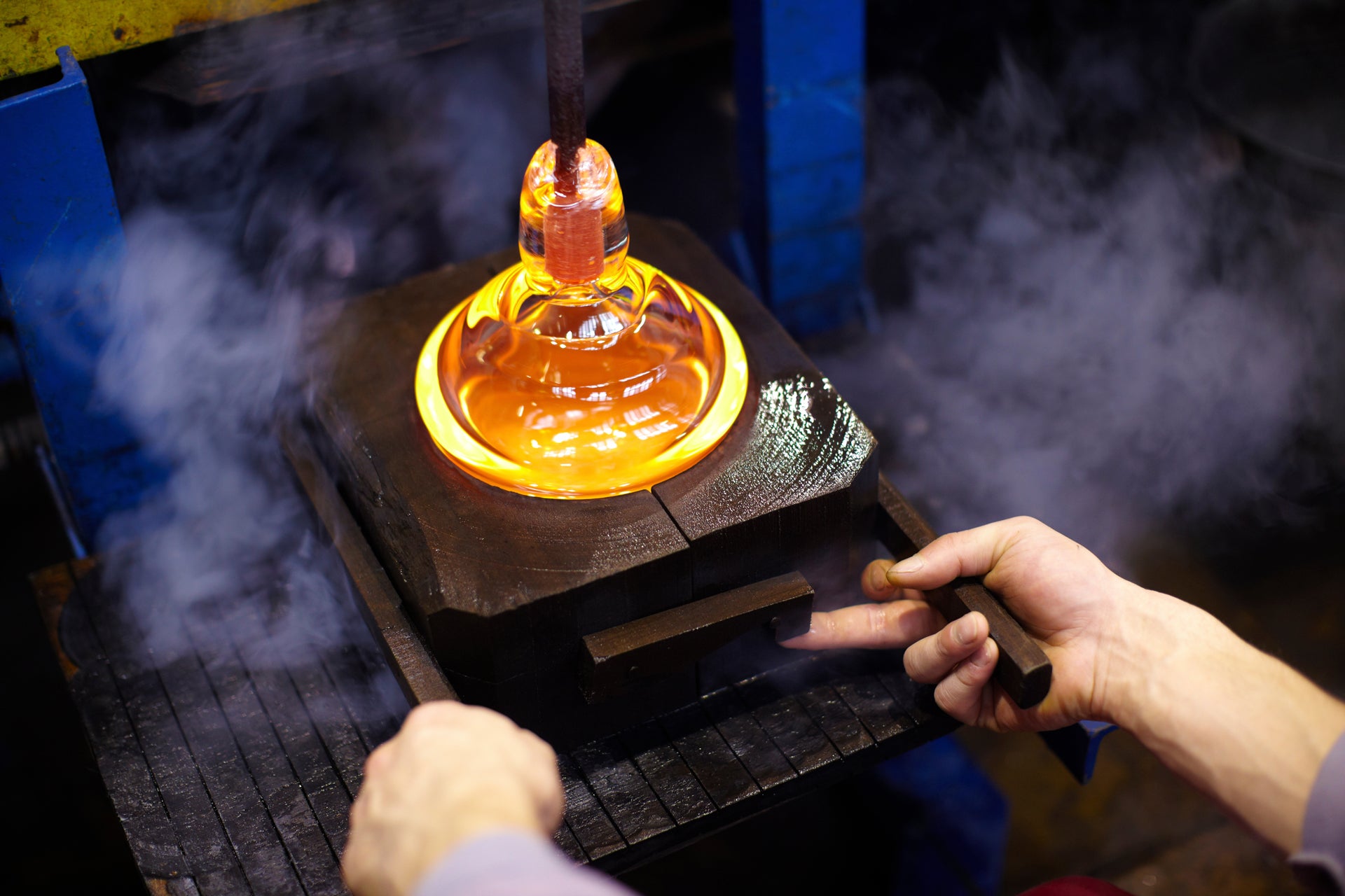 Glassworker casting glass in a mold