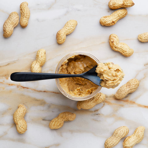 spoonful of crunchy peanut butter on top of jar