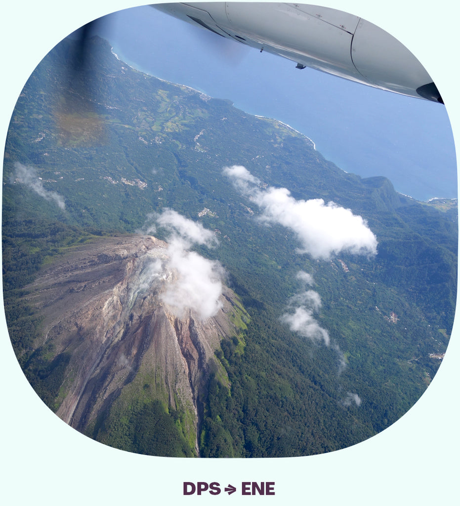 The propeller of an airplane and the view of a volcano below.