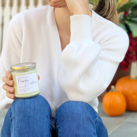 Woman holding pumpkin spice candle
