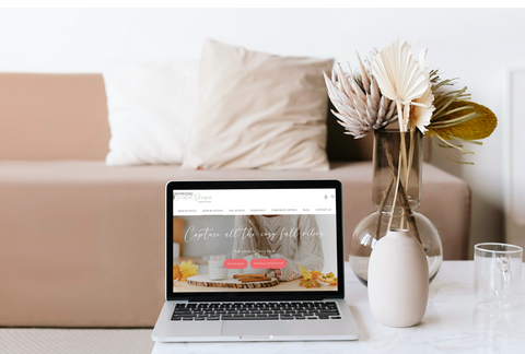 scented designs candle brand website on laptop on coffee table with couch 
