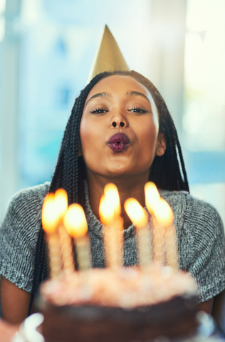 black woman blowing out birthday candles 