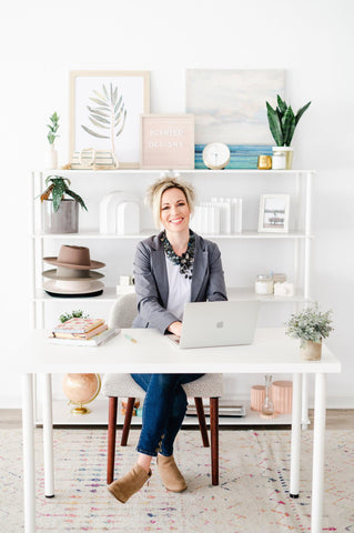 female business owner of scented designs candle company working at a laptop 