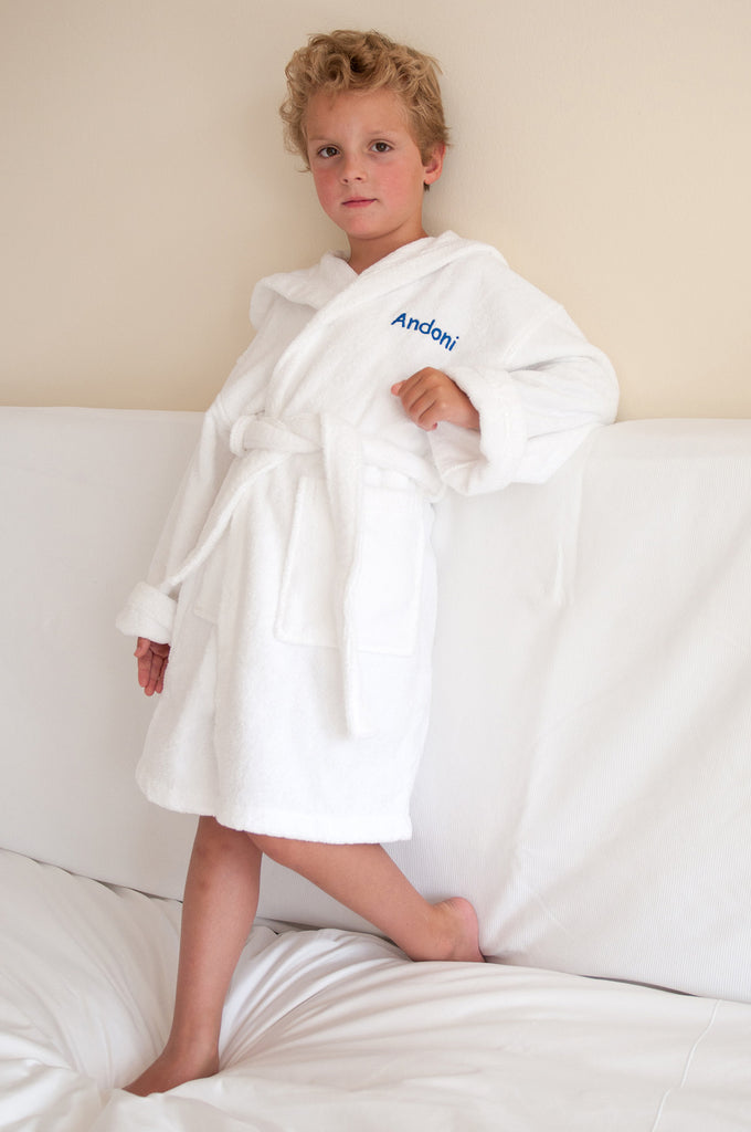 An emboridered bath robe for a child in a guest bedroom