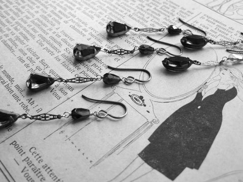 Vintage style earrings placed on an old magazine page.