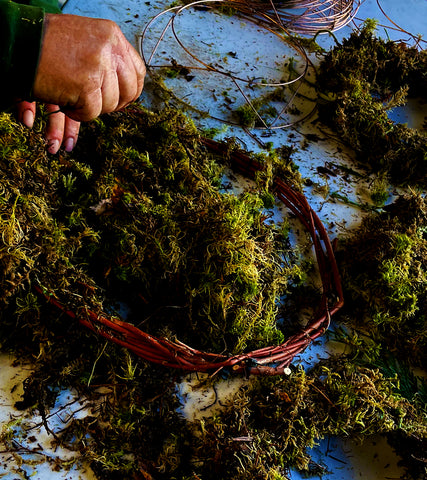 Kevin wraps moss around a pre-made wreath ring