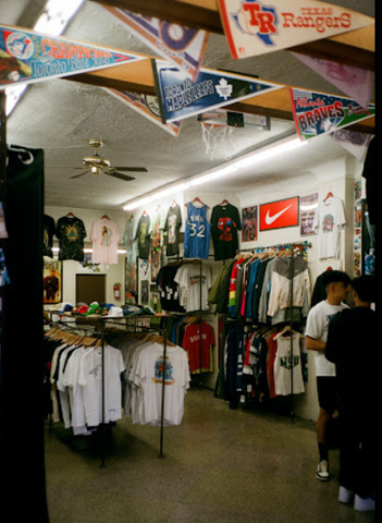 inside of vintage store with racks of tshirts and jerseys hung on the wall