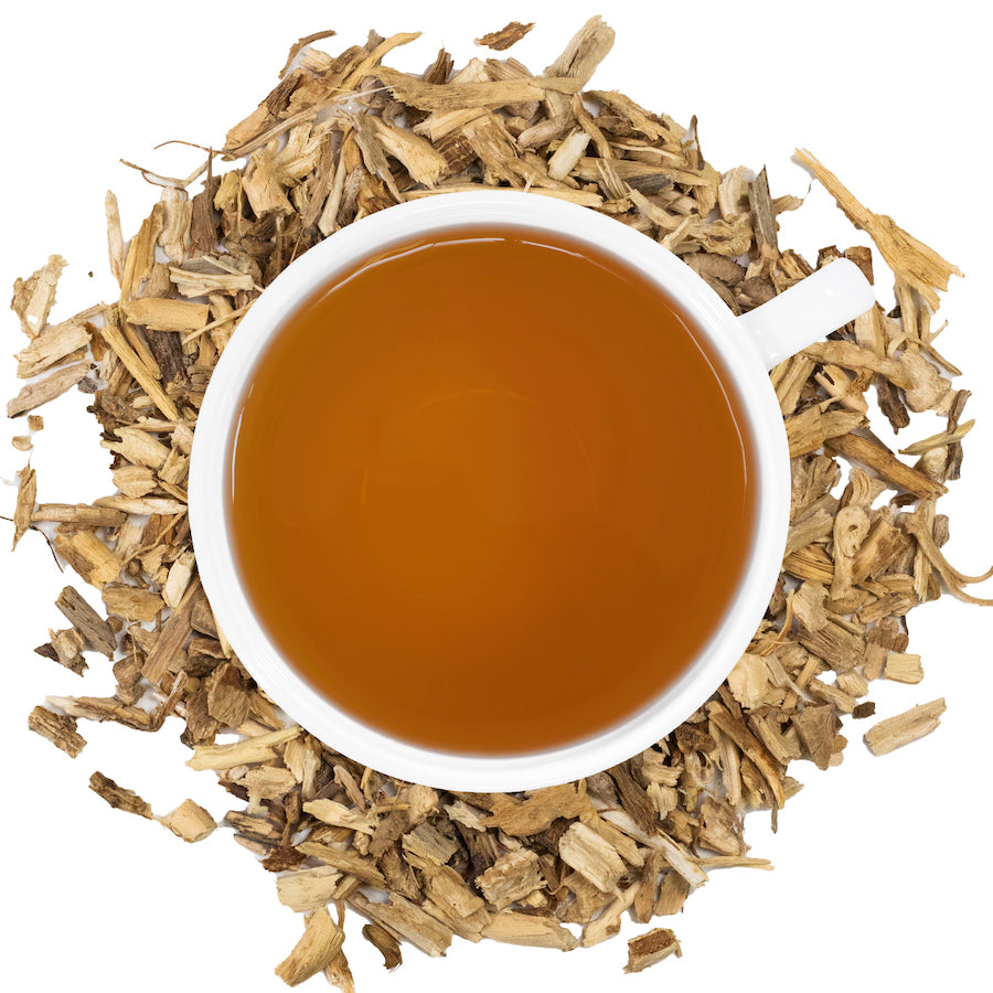 chicory tea in a white mug surrounded by dried chicory root