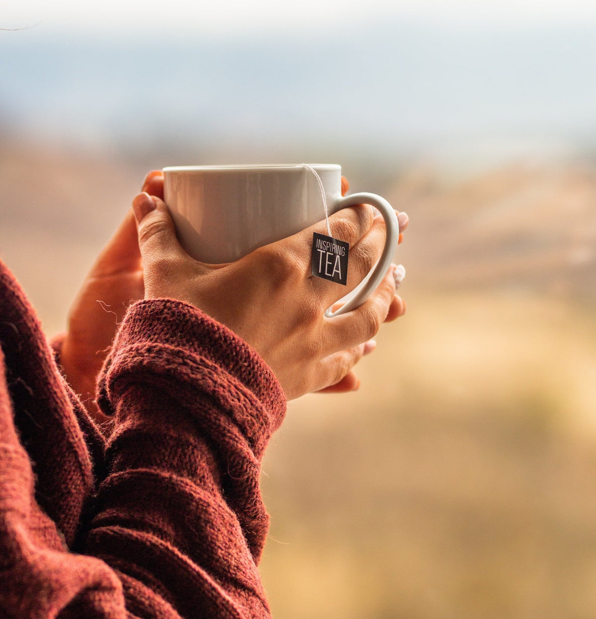 holding hot cup of tea