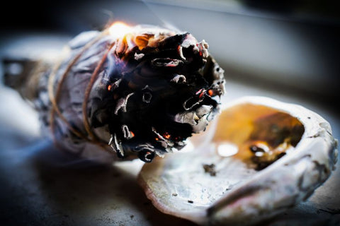 White sage smudge stick smoking over an abalone shell