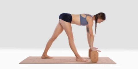 White woman in Parsvottanasana using blocks to rest hands