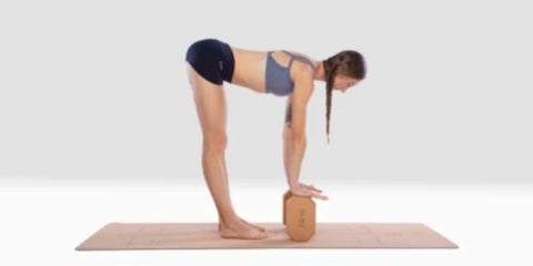 White woman in halfway lift pose using cork yoga blocks to rest her hands