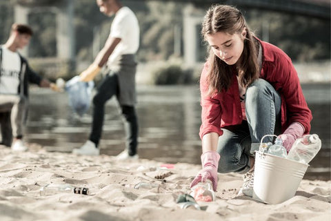 Woman cleaning up rubbish on a beach