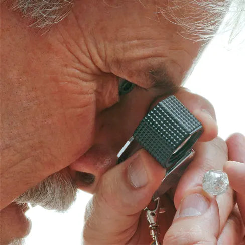 Jeweler with loop looking at diamond