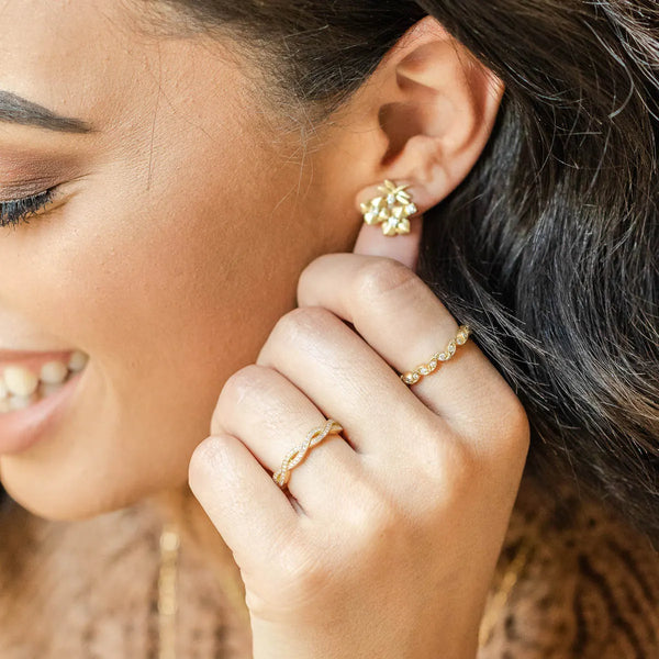 gold earrings with two rings on fingers