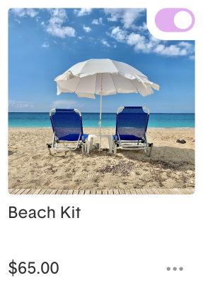 Two beach chairs and an umbrella on a sandy beach with a blue ocean backdrop.