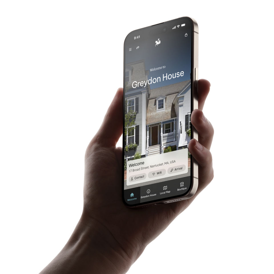 Hand holding smartphone displaying Greydon House welcome screen and contact information.