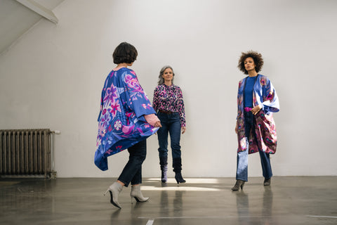 drie kruisende vrouwen: blauwe zijden kimono met bloemenprint, blauwe zijden blouse, blauwe zijden kimono met pauwenveren