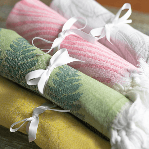 A bunch of Turkish towels ready to gift with a white bow on them