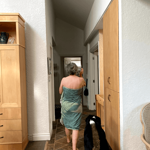 Elderly woman walks around in her home with a Turkish towel covering her