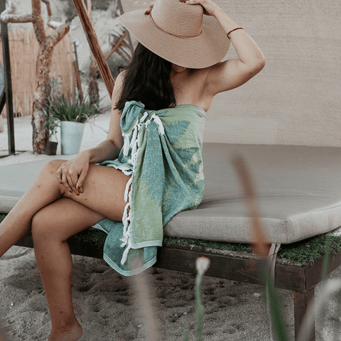 Woman wearing her Turkish towel as a sarong at the beach luxury