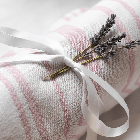 Pink and white Turkish towel wrapped in a white satin bow and lavender sprigs