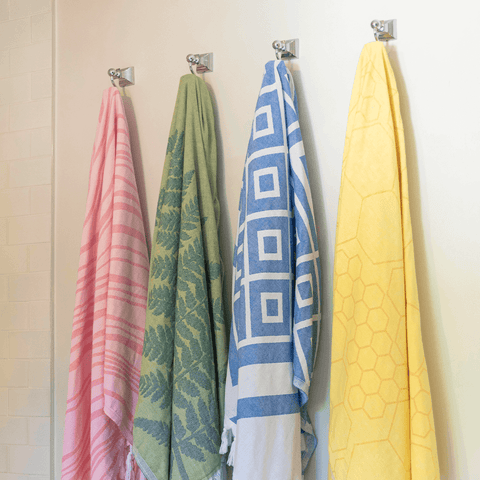 Colourful Turkish towels hang on hooks