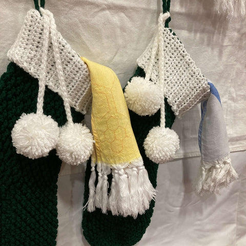 Two Turkish towels hanging from knitted stockings at the Seasons Christmas Show Booth