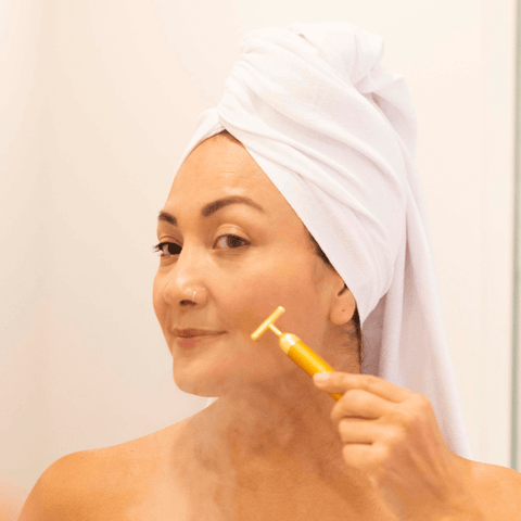 Latina woman shaving her face while using a white Turkish towel as a turban. 