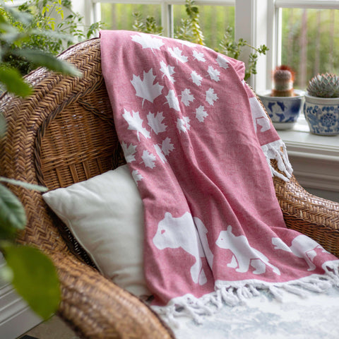 Turkish cotton towel in red and white with maple leaves and a bear family used as a decorative home accent in a sunroom