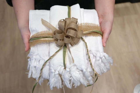 Two hands hold a set of Pomp & Sass Turkish cotton towels wrapped as a gift in the RBC eXperience Marketplace located in Sherway Garden Mall 2022