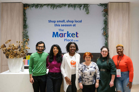 A diverse group of small business owners and vendors gather in front of the main desk at the RBC eXperience Marketplace located in Sherway Garden Mall 2022