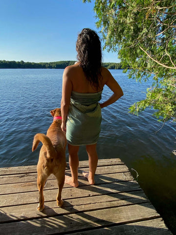 Woman and her dog on the dock wearing a green fern Turkish towel