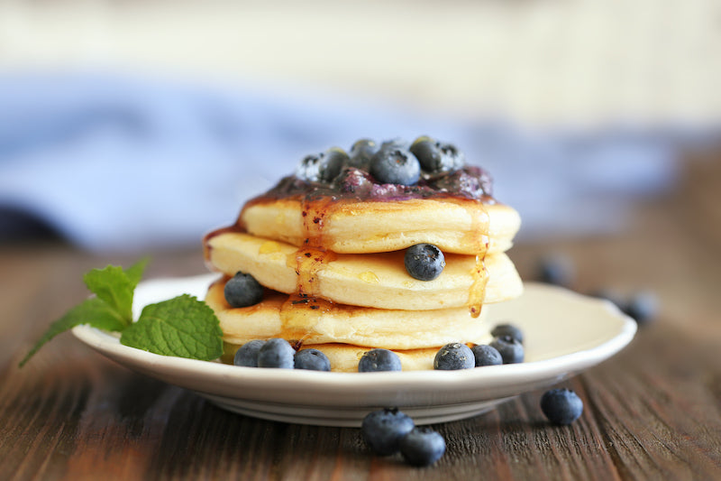 Stack of blueberry protein pancakes, topped with more blueberries