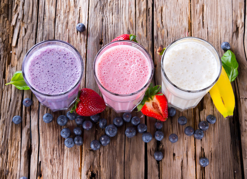 Three different flavored breakfast protein shakes, flavored with various berries