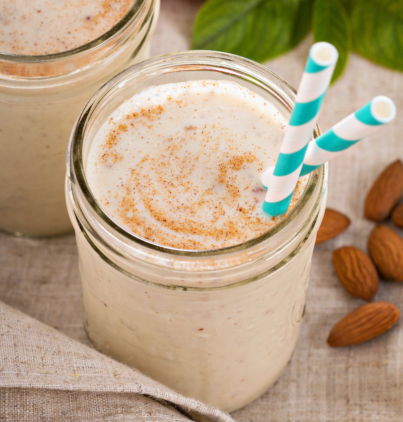 Cinnamon protein shake in a glass jar with paper straws