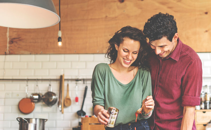 couple laughing and cooking together