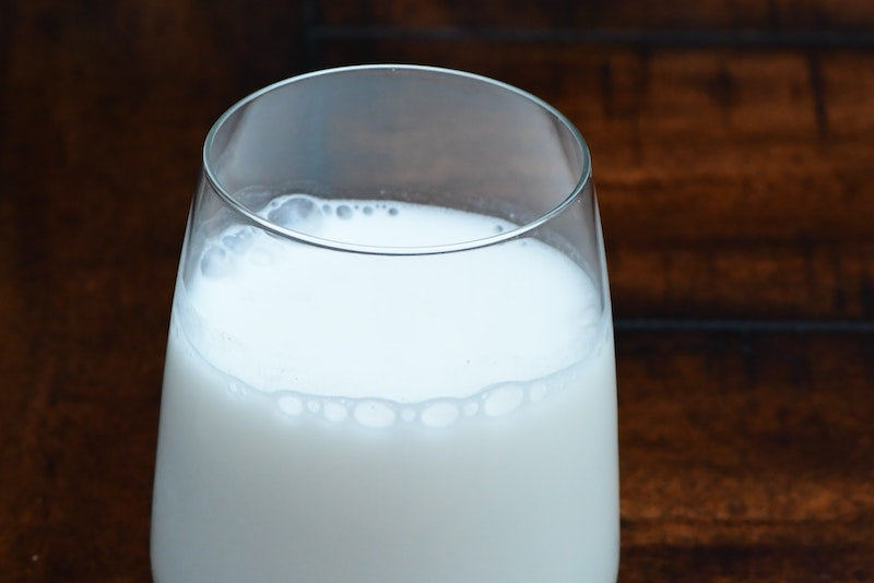 Glass of milk against a wooden background